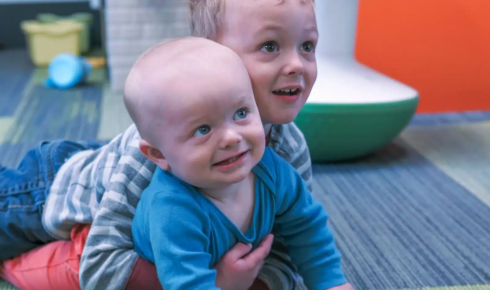 Two smiling young children playing at a pediatric clinic, lifestyle photography