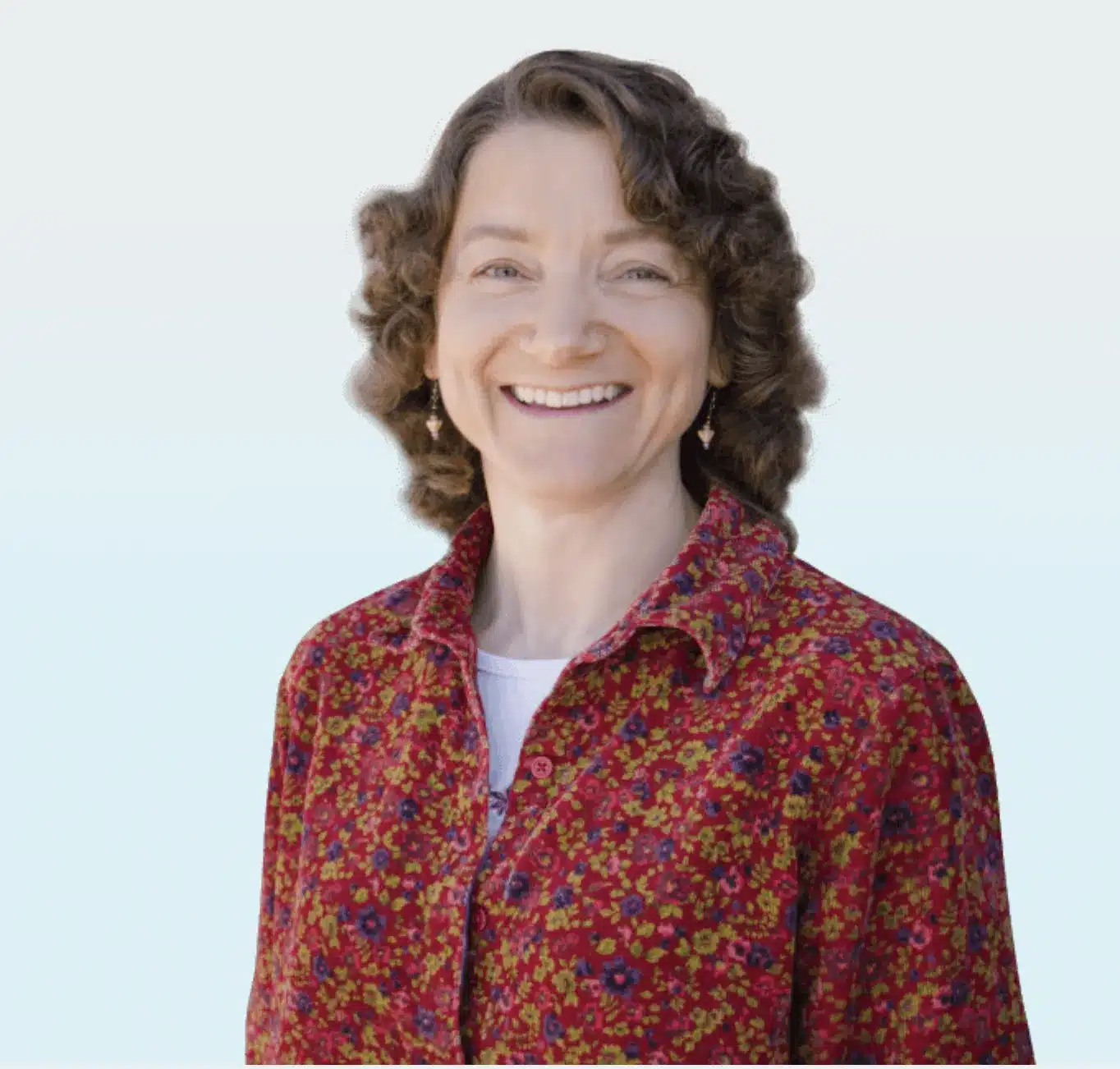 Professional studio headshot of a smiling provider on a light blue background