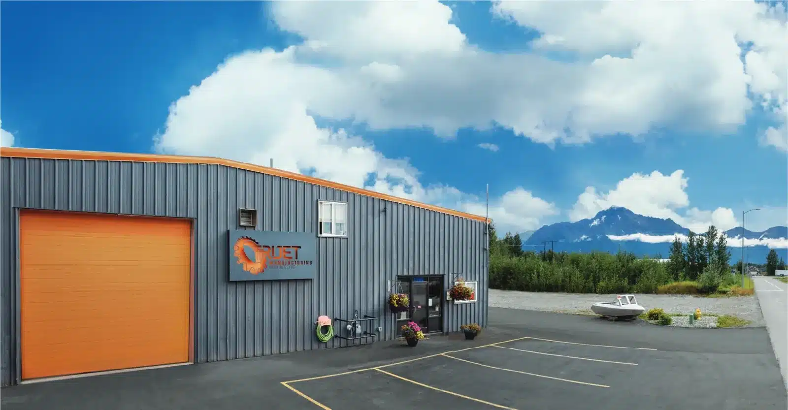 TriJet Precision shop exterior with mountain view, website banner design in Alaska